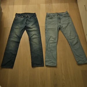 Två par Levi's jeans i olika blå nyanser - Säljer två par klassiska 501 Levi's jeans, ett par i mörkblå tvätt och ett par i ljusblå tvätt. Båda har raka ben, femficksmodell och klassisk jeanslook med läderpatch bak i midjan. Perfekta för dig som gillar tidlös denimstil. W29 L32