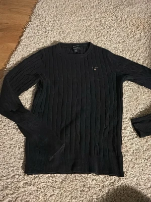 Blek blå kabelstickad tröja från Gant - Kabelstickad mörkblå tröja från Gant. Inte använt den super mycket tröjan blev för liten men jag önskade att den fortfarande passade det är en mycket fin tröja.
