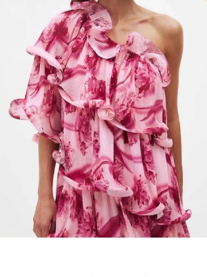 Rosa blommig oneshoulder klänning - Säljer en kort rosa klänning med blommigt mönster och volangdetaljer. Från nakd. Helt slutsåld🥰 den är stor i storleken. Har normalt 36 men 32 satt jätte bra då den väldigt stor i storlek