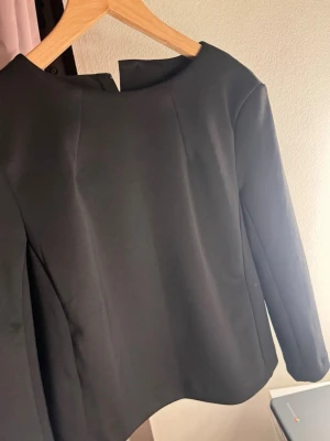 Svart långärmad topp med rund hals från mango - Stilren svart topp med mellan lång ärm och rund halsringning , är något croppad i modellen. 