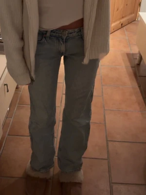 Weekday arrow low jeans - Säljer ett par ljusblå jeans med rak passform och ganska låg midja. Jeansen har en femficksdesign och stängs med dragkedja och knapp. Bra skick, hör av er vid frågor! (Storlek w24/L30)