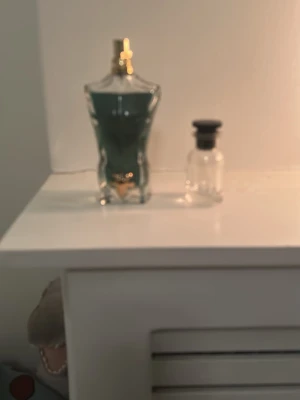 Jean Paul Gaultier Le beau parfym - Säljer en Jean Paul Gaultier Le Male parfym i den ikoniska manliga bystformade flaskan. Flaskan är i glas med blågrön färg och gulddetaljer på korken. Perfekt för dig som gillar klassiska och fräscha dofter.