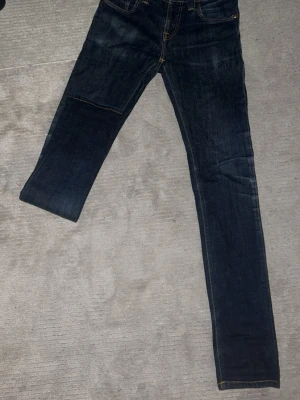 Mörkblå raka jeans med klassisk look - Snygga mörkblå jeans med raka ben och klassisk femficksdesign. Jeansen har kontrastsömmar och en tidlös passform som funkar till det mesta. Tillverkade i slitstarkt denimtyg för en autentisk jeanskänsla.  W27 L34