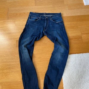 Polo Ralph Lauren Sullivan Slim jeans - Mörkblå jeans från Polo Ralph Lauren, modell Sullivan Slim. Klassisk femficksdesign med snygga kontrastsömmar och diskret logga på myntfickan. Slim passform och tillverkade i mjukt bomullsjeans. Perfekta för dig som gillar stilrena och tidlösa jeans. Näsan helt nya!
