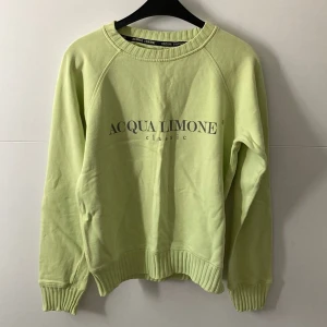 Ljusgrön sweatshirt från Acqua Limone - Fräsch ljusgrön sweatshirt från Acqua Limone med klassisk logga tryckt på bröstet. Tröjan har rund hals, ribbade muddar vid ärmslut och nederkant samt långärmad passform. Perfekt för chill dagar och enkel att matcha med jeans eller tights.