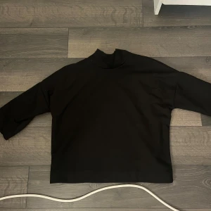 Svart polotröja från Carin Wester XS - Svart polotröja från Carin Wester i storlek XS. Tröjan har en hög krage och raka, långa ärmar. Enkel och stilren design som passar perfekt till lager-på-lager eller som den är. Materialet känns mjukt och bekvämt mot huden.