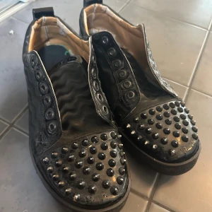 Svarta loubs 40/41 - Svarta Louboutin skor med nitar, skorna saknar sko snören och är väl använda. Skick 3/10 och har deffekter som saknade nitar