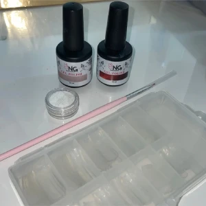 NG Gel Polish nagelkit med glitter - Nagelkit med två gel polish från NagelGiganten i olika nyanser:  - röd & lila -pensel för nageldesign -vitt glitter -transparenta lösnaglar.