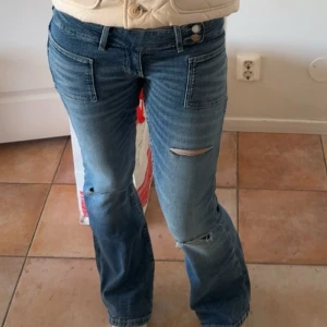 Blå bootcut jeans med slitningar - Snygga blå jeans med bootcut-modell och slitningar på båda benen. Jeansen har framfickor med markerade sömmar och klassisk femficksdesign. Perfekta för en avslappnad och trendig look. skitsnygga jeans från gina, jag är 169 och passar mig toppen!! skriv vid frågor 💕💕priset kan diskuteras 
