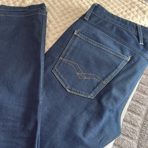 Blå Replay Anbass jeans herr - Säljer ett par klassiska blå Replay Anbass jeans med snygga kontrastsömmar och femficksdesign. 