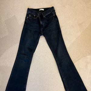 Bootcut jeans från Gina Tricot - Snygga mörkblå bootcut jeans från Gina Tricot, modell Perfect Jeans. Klassisk femficksdesign med smal passform upptill och utsvängda ben. Jeansen är tillverkade i stretchigt denim för extra komfort och har en stilren look.