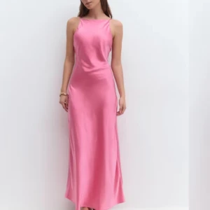 Rosa lång satinklänning med smala band - (Klänningen är endast testad hemma, aldrig använd) Säljer en superfin långklänning i glansig rosa satin med smala axelband och hög halsringning. Pris kan diskuteras vid snabb affär!