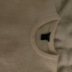 Beige stickad kortärmad tröja Lindex XS - Supermysig beige stickad tröja från Lindex i storlek XS. Tröjan har korta ärmar, rund halsringning och ribbade muddar. 