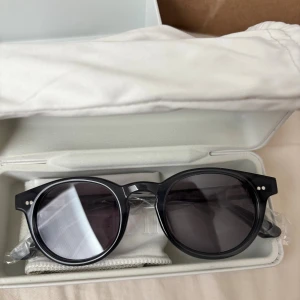 Mörkgrå CHIMI solglasögon rund - Snygga solglasögon från CHIMI i modellen 03.3 Dark Grey. De har rund form, mörkgrå bågar och mörka linser. Kommer i originalförpackning med fodral och putsduk.