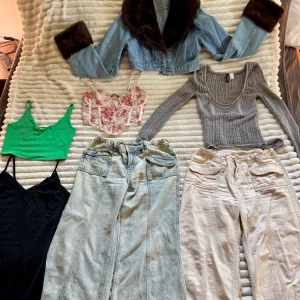 7 plagg säljs i ett paket  - Ett par ljusblå wide jeans och ett par beige med stora fickor framtill. Kort klänning, grönt v-ringat linne, kort jeans jacka, grå långärmad hyfsat tajt samt en blommig ”korsett” topp. Är man sugen på något plagg och inte alla 7 så skriv och kom på ett bra pris så löser vi det. Kan skicka bilder med kläderna på vid begäran. Tröjorna & klänning strl S. Byxorna strl 38 men har sytt in dem i midjan, går att återställa. Vissa plagg helt oanvända.