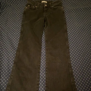 Svarta bootcut jeans från Perfect Jeans - Svarta lågmidjade jeans från Gina Tricot i klassisk bootcut-modell. Jeansen har fem fickor, knapp- och dragkedjestängning samt snygga bakfickor med lock och knapp. Materialet är jeans och passformen är normal med utsvängda ben. Pris kan diskuteras.