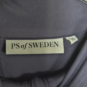 Marinblå half zip tröja PS of Sweden XL - Ridsätt från PS of Sweden.                                Sportig marinblå långärmad tröja från PS of Sweden i storlek XL. Tröjan har half zip framtill, synliga sömmar och diskret logga längs ryggen. Materialet är mjukt och stretchigt polyester, perfekt för träning eller ridning. Ridbyxor från PS of siden med synliga sömmar och fickor på sidan materialet mjukt och stretchig. 