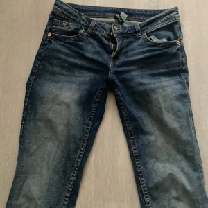 Mörkblå lowwaist bootcut jeans - Snygga mörkblå jeans med bootcut passform och klassisk femficksdesign. Jeansen har en lätt tvättad look och är tillverkade i slitstarkt denim. 