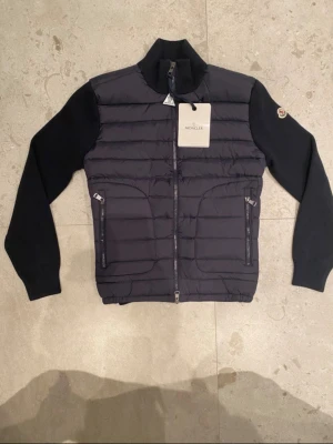 Moncler cardigan tricot - Säljer en oanvänd moncler cardigan  gricot i svart färg, jackan har inga defekter, den är sparsamt använd. Priset är diskutabelt 