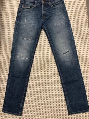 Blå jeans från Jack & Jones - Snygga blå Jack & Jones jeans i slim fit-modell. Klassisk tvätt med lätt slitning som ger en clean men edgy look. Passar perfekt till vardags och funkar året runt.  👖 Slim fit 🎨 Blå denim ✨ Fint begagnat skick 🧵 Sköna och slitstarka  Inga större defekter, endast normal användning. Skickas snabbt 📦