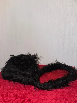 Svart fluffig axelväska - Its fur no issue as i can see