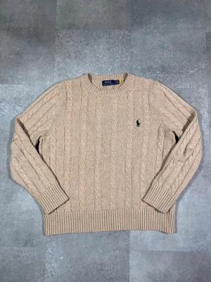 Ralph Lauren cable knit sweater  - Säljer en Ralph Lauren cable knit sweater i snygg beige färg. 🧵 Märke: Ralph Lauren 👕 Storlek: Medium (men passar mer som S) 🎨 Färg: Mörkblå / navy 📌 Design: Klassisk cable knit-stickad tröja 📍 Skick: Mycket bra, se bilder!  Beskrivning: • Tidlös och stilren cable knit-design från Ralph Lauren • Bekväm och varm – perfekt för höst och vinter • Ribbstickade muddar och kant för bra passform • Inga fläckar, noppor eller skador (kontrollera bilder) • Lätt att matcha med jeans, chinos eller över skj