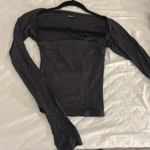 Mörk grå långärmad topp Gina Tricot XS - Säljer en svart långärmad topp från Gina Tricot i storlek XS. Toppen har en slim passform och är tillverkad i ett mjukt och stretchigt syntetmaterial.