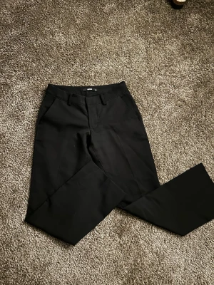 Svarta kostymbyxor  - Svarta kostymbyxor ifrån Bikbok. De är i strl 34 men är uppsydd till ish 160cm 