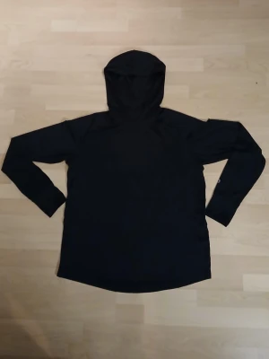 Svart huvtröja från studio total  - Svart huvtröja i polyester och elestan 