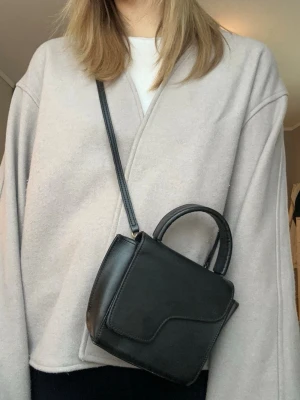 Beige kofta/jacka från Kappahl - Säljer en stilren beige omlottjacka från Kappahl. Jackan har en enkel och clean design utan knappar eller dragkedja, med lång ärm och mjukt material. Perfekt för lager-på-lager och passar till många olika outfits.