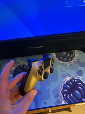 Sony DualShock 4 Gold - Snygg och välfungerande Sony DualShock 4 trådlös handkontroll i guld. Passar till PlayStation 4. Kontrollen är i fint skick med minimalt slitage och alla knappar fungerar som de ska. Perfekt för dig som vill ha en extra eller ersätta din gamla kontroll.
