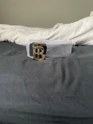  Burberry bälte - Ett burberry bälte som kan varieras mellan svart och beige med en guld buckle