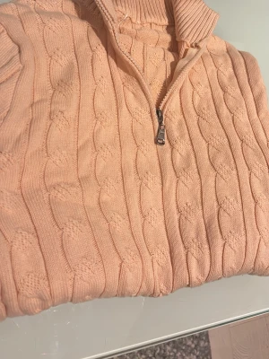 Beige kabelstickad half zip tröja - Säljer en beige kabelstickad tröja med half zip och hög krage. Tröjan har långa ärmar och ribbade muddar vid ärmslut och nederkant. Perfekt för lager på lager under hösten och vintern. Supermysig och stilren att matcha med jeans eller linnebyxor eller vad som😁