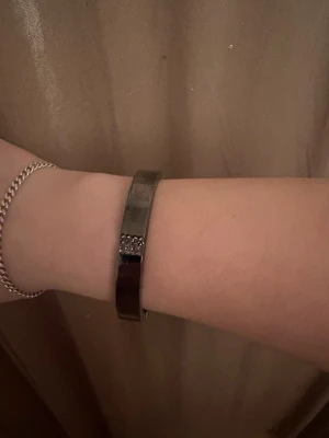 Ett metall armband  - Ett jätte fint metall armband med stenar i mitte, den är aldrig använd. Ingen aning vad det är för märke 
