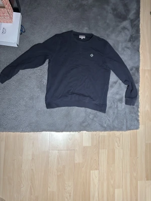 Svart sweatshirt från Morris - Säljer en svart sweatshirt från Morris med rund hals och diskret broderad logga på bröstet. Tröjan har långa ärmar och är gjord i mjuk bomull, perfekt för en clean och stilren look. Hör av er vid minsta fundering!🙌