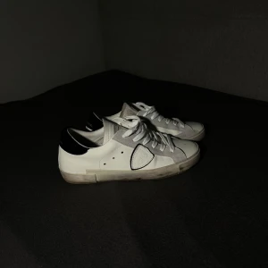 Philippe Model vita sneakers med svarta detaljer - Snygga Phillipe Models till salu! Bra skick, lite smutsiga runt sulan. Hör av dig vid funderingar😀