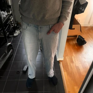 Ljusblå jeans från Pull&Bear, strl 40 - Säljer ett par ljusblå jeans från Pull&Bear i storlek 40. Klassiska ”baggy” Jeans, storleken jag har står att det är 40 men skulle själv säga att det är 31-32 midja ungefär, är 194 och väger 78-80 och är lite för små för mig för att ta på sig och tänka att det är baggy. Nypris: 429