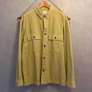Ljusgrön manchester overshirt H&M XL - Säljer en ljusgrön overshirt från H&M i manchester med relaxed fit. Skjortan har två stora bröstfickor med knappar och klassisk krage. Perfekt lager-på-lager-plagg med snygga svarta knappar och lång ärm.