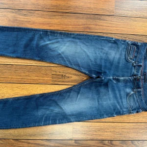 Tommy Hilfiger Bleecker stretch slim fit blå jeans - Schyssta Tommy Hilfiger blå jeans med skön stretch och snygga slitningar.                                    Svarar gärna på frågor och skickar fler bilder ifall det önskas.                                                                     Priset kan diskuteras vid snabb affär.