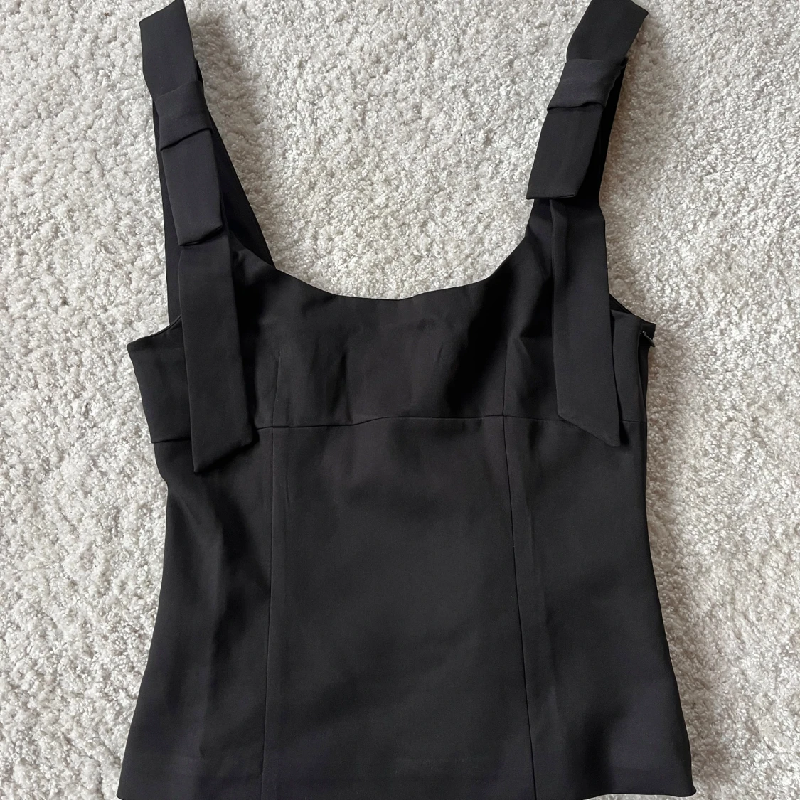 Svart topp med rosetter 