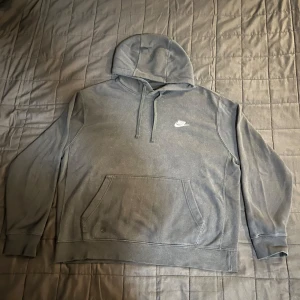 Svart Nike hoodie - Säljer en svart hoodie från Nike med klassisk logga på bröstet. Tröjan är i använt skick, därav ett lägre pris på en sådan Nike hoodie!