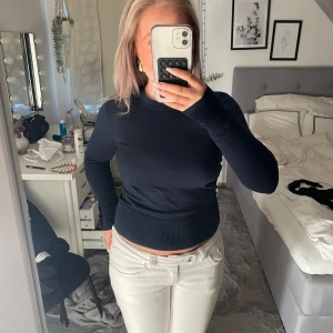 Mörkblå tröja Holly & Whyte XS - Mörkblå, figurnära tröja från Holly & Whyte by Lindex i storlek XS. Tröjan har rund halsringning, långa ärmar och snygga guldfärgade knappar vid ärmsluten. Mjuk och stretchig bomullsblandning, perfekt till jeans eller kjol.