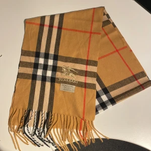 Burberry halsduk - Riktigt snygg burberry halsduk i 100% Kashmir, använd ett fåtal gånger men i riktigt bra skick, perfekt för snygga vinter outfits som den på sista bilden, skriv vid frågor !