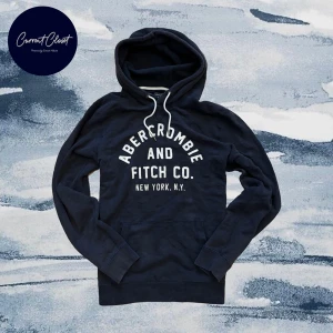 Svart hoodie Abercrombie & Fitch - Mörkblå hoodie från Abercrombie & Fitch med vit broderad logga på bröstet och klassisk känguruficka | Size M/L | Längd: 68cm Axelbredd: 44cm