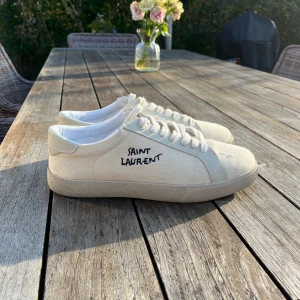 Saint Laurent skor - Snygga vita sneakers från Saint Laurent med handskriven logga på sidan. Har inte använt de mycket. OBS! Har inte box eller kvitto och är förmodligen kopior och därav priset. Men inget fel på utseendet eller kvaliten