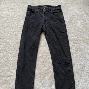 Svarta relaxed jeans Jack & Jones 29/32 - Svarta jeans från Jack & Jones i modellen Relaxed/Chris. De har en avslappnad passform med raka ben och klassisk femficksdesign. Jeansen är tillverkade i bomull och har en enkel, stilren look som passar till det mesta.