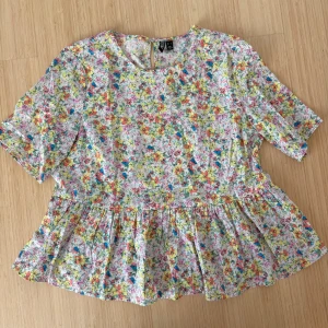 Blommig topp  - Fin topp från Pieces! 🌺💐Storlek L, men har själv storlek M och den sitter bra. Säljer pga kommer inte till användning längre. Endast använd fåtal gånger!!