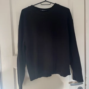 Svart stickad tröja med rund hals - En svart stickad tröja med rund halsringning och ribbade muddar. Tröjan har en klassisk, enkel design och långa ärmar. Perfekt för lager-på-lager och passar till allt. Snygg och basic i garderoben. Det är hyfsat använd och lite nopprig därav priset, men inget jag tycker märks när man har på sig den💕