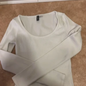 Vit ribbad långärmad topp H&M Divided - Säljer en vit ribbad långärmad topp från H&M Divided i storlek XS. Toppen har rund halsringning och är figurnära i modellen. Perfekt att styla med jeans eller kjol för en clean och fräsch look.