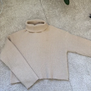 Beige stickad polotröja - Supermysig beige polotröja från SHEIN med ribbat stickat material. Tröjan har lång ärm, hög polokrage och en loose fit som ger en chill vibe. Perfekt för lager på lager under höst och vinter. Storlek 152💕